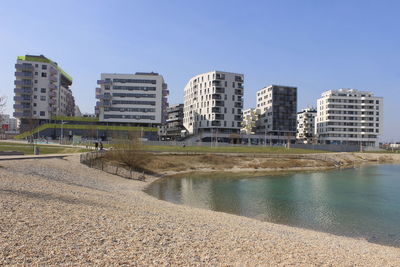 City at waterfront against clear sky