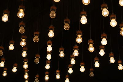 Low angle view of illuminated lights hanging from ceiling