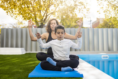 Mother and son doing yoga exercises in their home garden