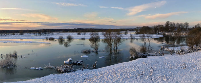 Scenic view of frozen lake against sky during sunset