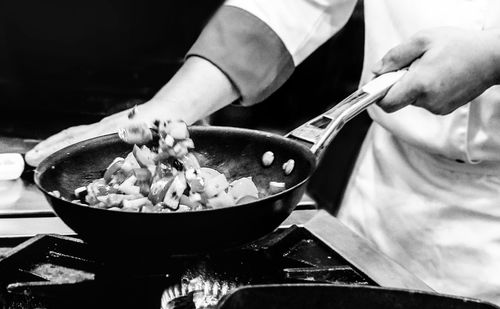 Midsection of person preparing food in kitchen