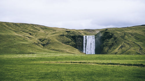 Scenic view of waterfall against sky