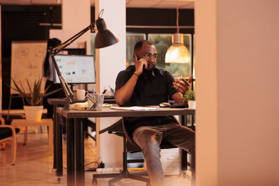 Businessman talking on smart phone at office