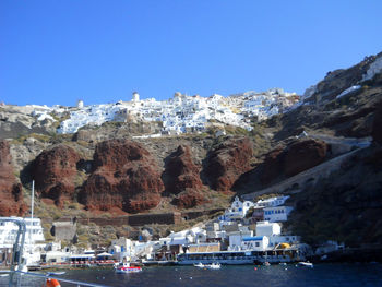 Scenic view of sea by buildings against clear sky