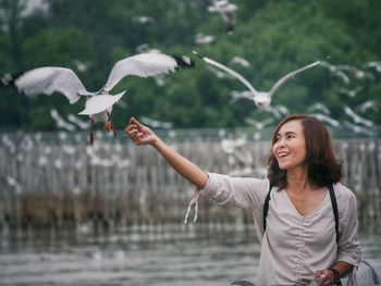 Young woman flying birds in water