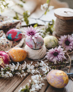 Close-up of painted eggs and purple flowers on table