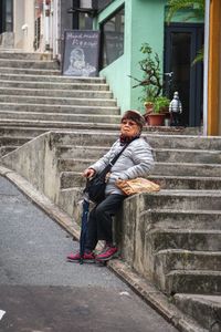 Man sitting on staircase in city