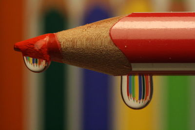 Close up of drops on red colored pencil