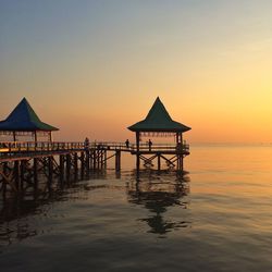 Pier on sea at sunset