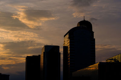 Low angle view of buildings against cloudy sky