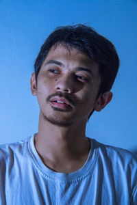 Portrait of mid adult man against blue background