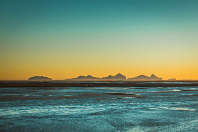 Scenic view of sea against clear sky during sunset