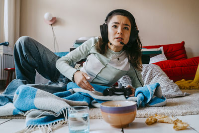 Woman playing video game in living room at home