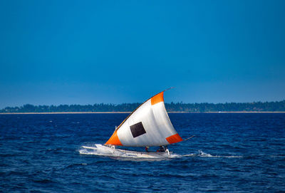 Traditional balinese outrigger boat with sails