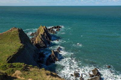 High angle view of rocks at sea shore against sky