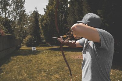 Man shooting arrow on a target while standing on land