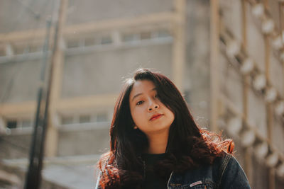 Portrait of beautiful young woman standing outdoors