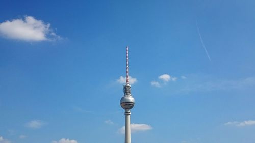 Low angle view of communications tower against cloudy sky