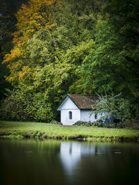 House by lake and trees in forest