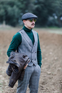 Young man wearing hat standing on field