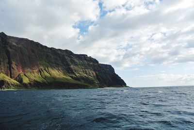 Scenic view of sea and mountains against sky