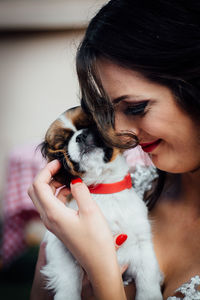 Close-up of woman holding dog at home