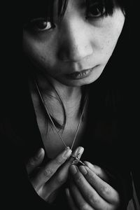 Close-up high angle portrait of young woman in dark