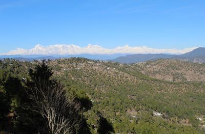 Scenic view of landscape and mountains against blue sky