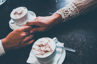 Cropped image of woman holding coffee cup