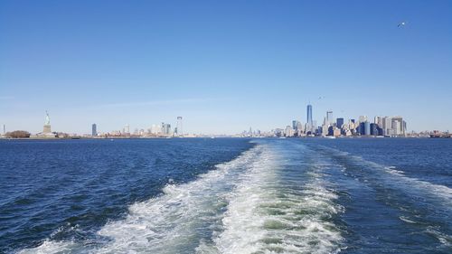 Panoramic view of sea and buildings against blue sky