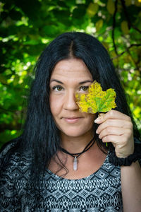 Portrait of young woman holding yellow flower