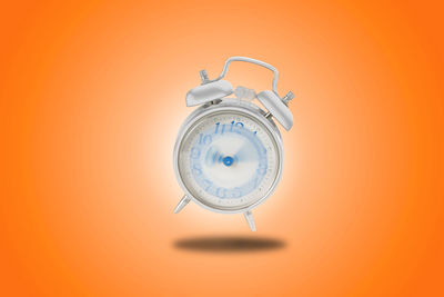 Close-up of clock against orange background