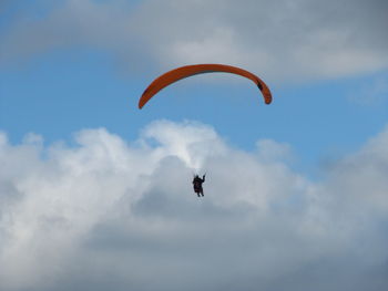 Low angle view of person paragliding against sky