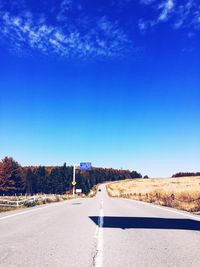 Road on landscape against clear blue sky