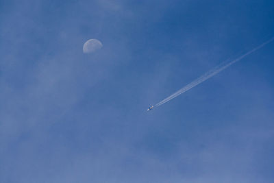 Low angle view of vapor trail against blue sky