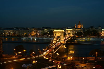 Illuminated light trails on chain bridge at night