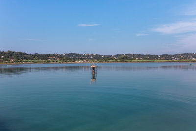 Man standing by swimming pool in lake against sky