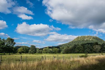 Scenic view of field against cloudy sky