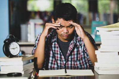 Portrait of teenage girl sitting on book