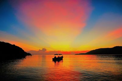 Silhouette boats in sea against sky during sunset