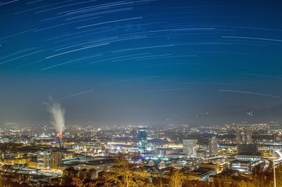 Illuminated cityscape against sky at night