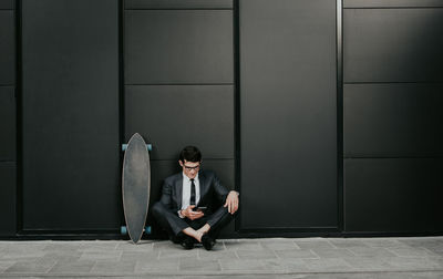 Full length of a man sitting on wall