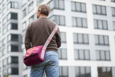 Rear view of man standing against buildings in city