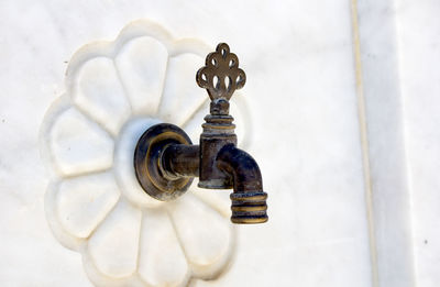 Close-up of faucet on white wall