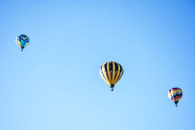 Low angle view of hot air balloon against clear blue sky