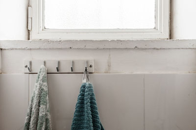 Towels hanging on coathanger in bathroom