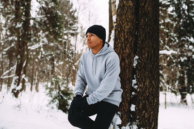 Full length of young man in forest during winter