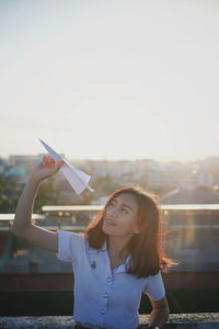 Portrait of happy woman standing against sky