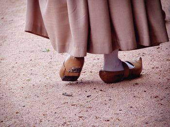 Low section of woman walking in wooden shoes