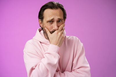 Portrait of man against pink background